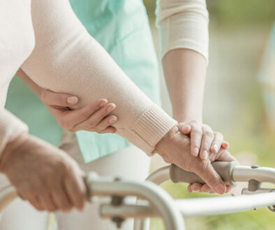 Closeup of elderly lady's hands holding a walker and supporting